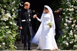 Britain's Prince Harry, Duke of Sussex and his wife Meghan, Duchess of Sussex leave from the West Door of St George's Chapel, Windsor Castle, in Windsor on May 19, 2018