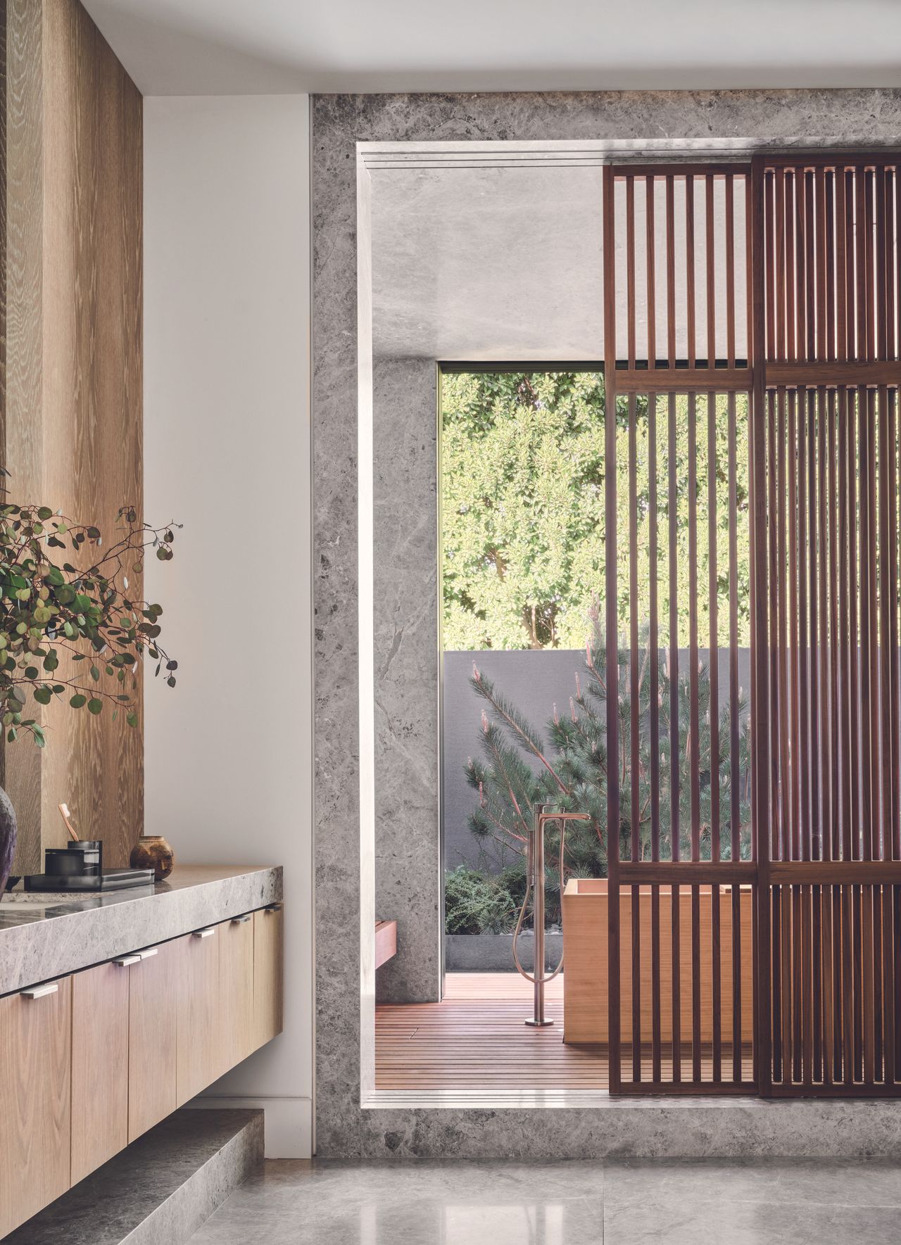 Open plan bathroom from the inside, with a bath tub overlooking the outdoor space