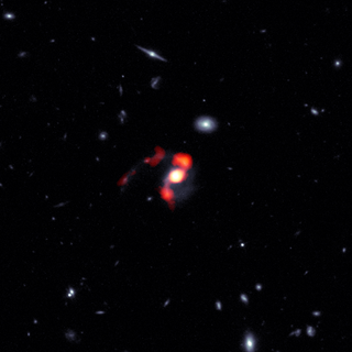 This composite image combines blue/white data from the Hubble Space Telescope (HST) and red/orange data from the Atacama Large Millimeter/submillimeter Array (ALMA) to show the post-merger distribution of gas and stars from the now-dormant galaxy into streams of material known as tidal tails.