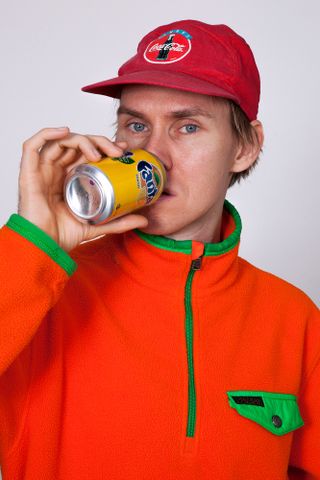 Man with cap drinking Fanta
