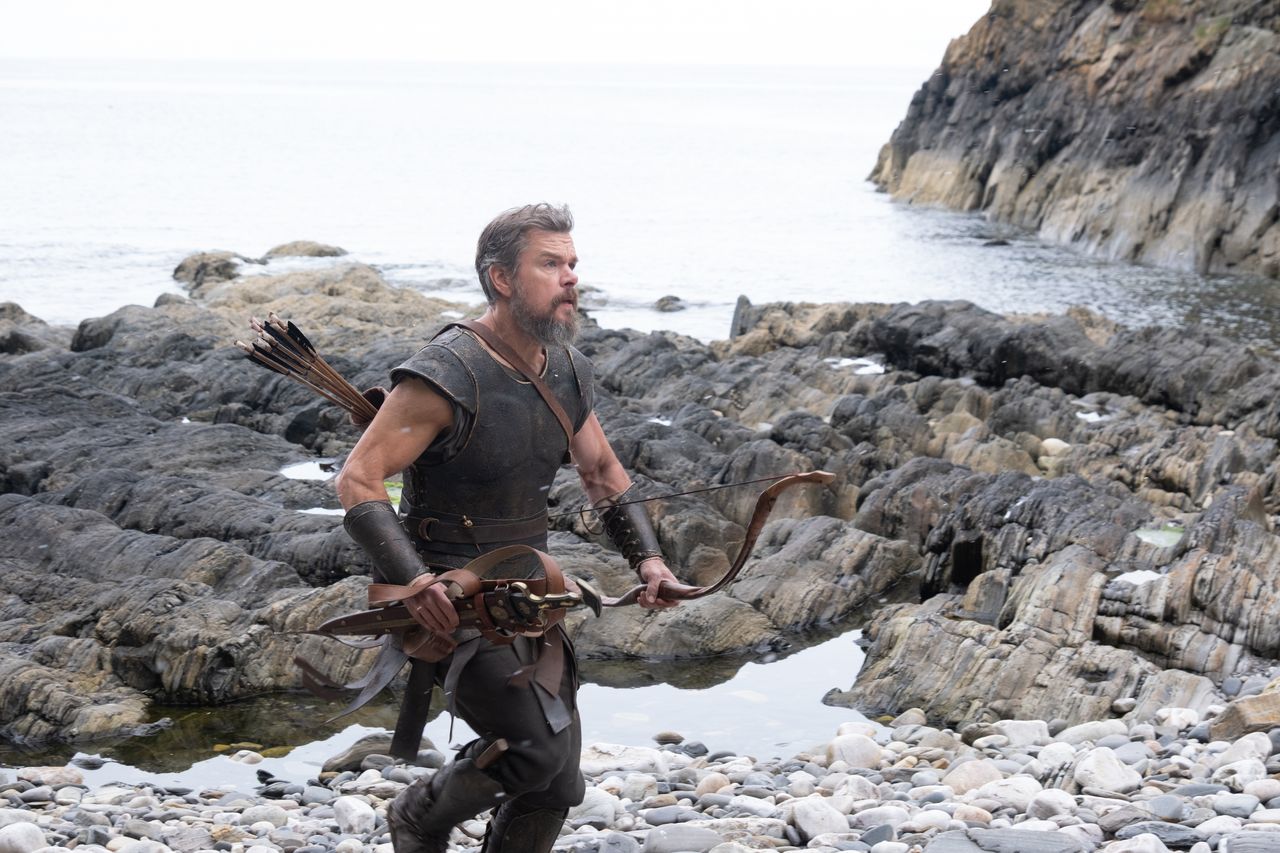 A series of set shots of actors dressed in period clothing, filming along rugged coasts, tranquil sandy beaches, and rocky fortresses.