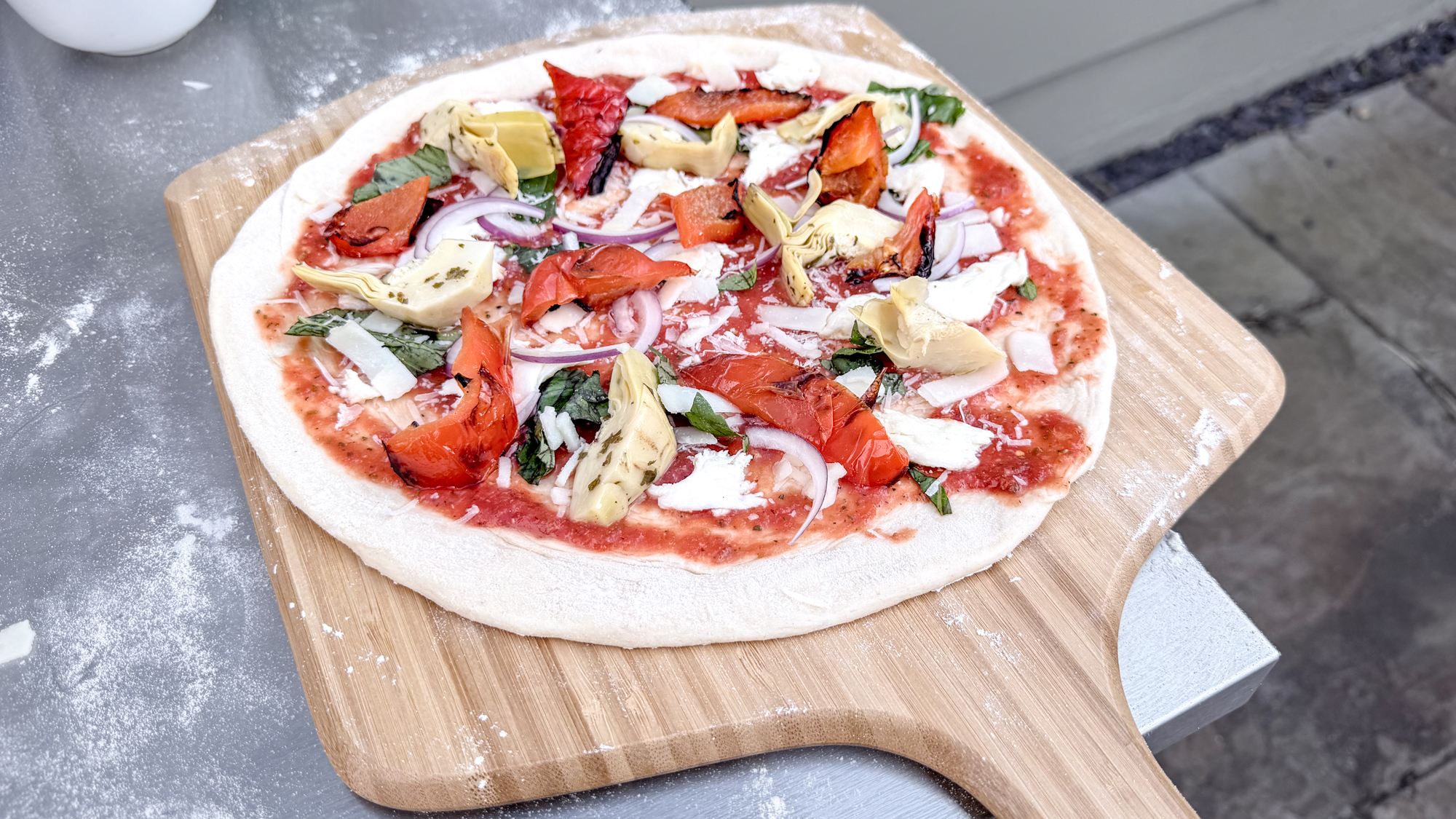 A pizza on a pizza peel before being cooked