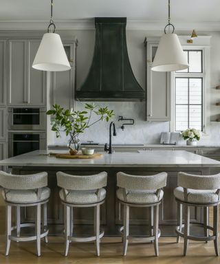 gray kitchen with large island four stools and black hardware