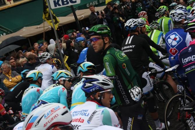 The riders wear their rain jackets as the rain falls in Bruges