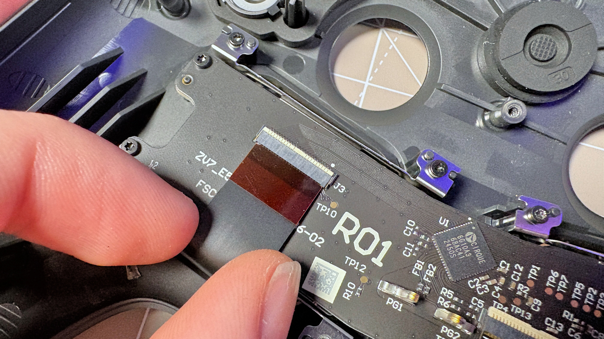 The Steam Controller on a desk during a teardown, with various parts removed.