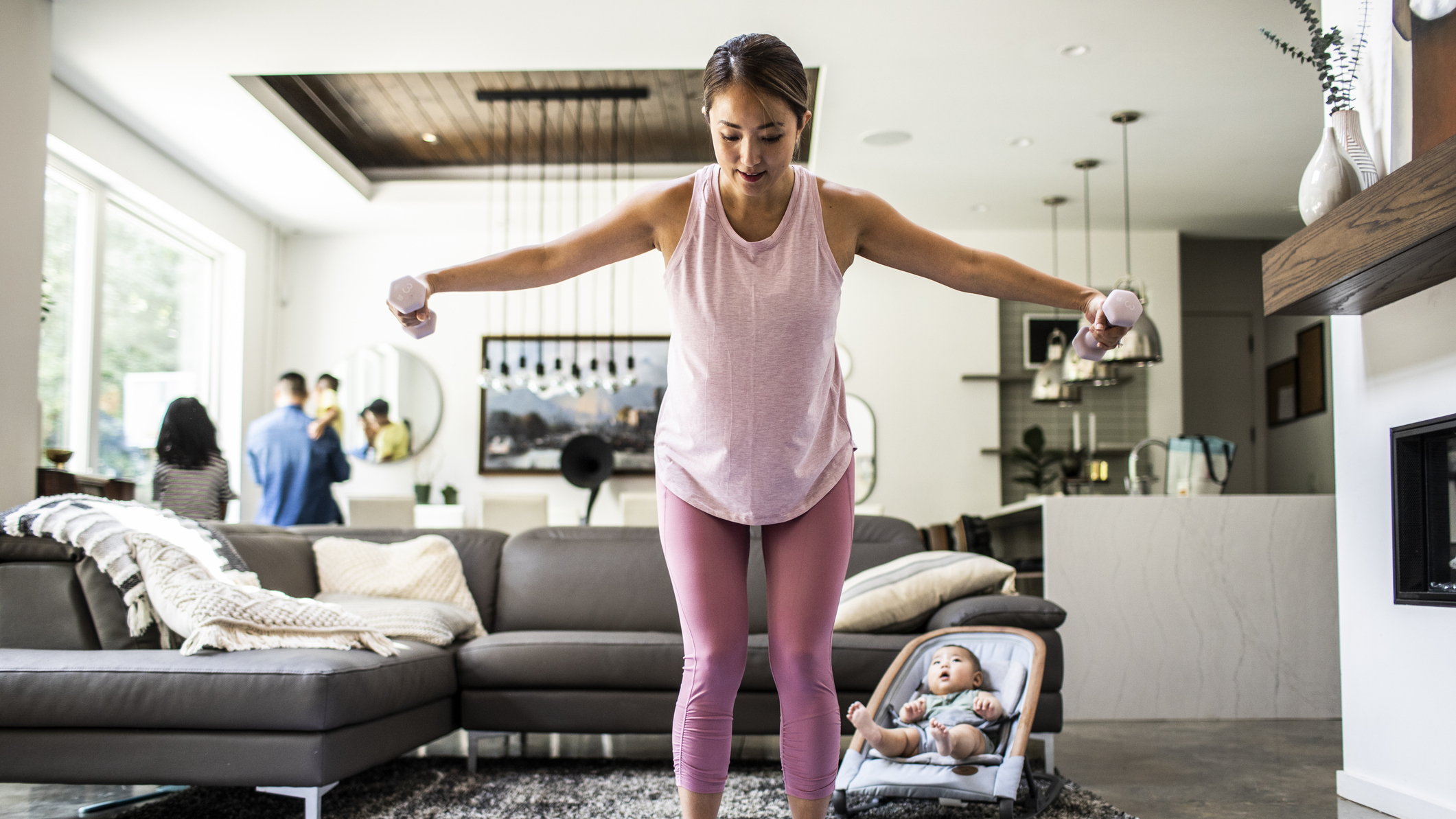 Woman exercising with dumbbells in domestic setting