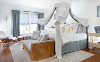 A four poster bed with tied fabrics around it