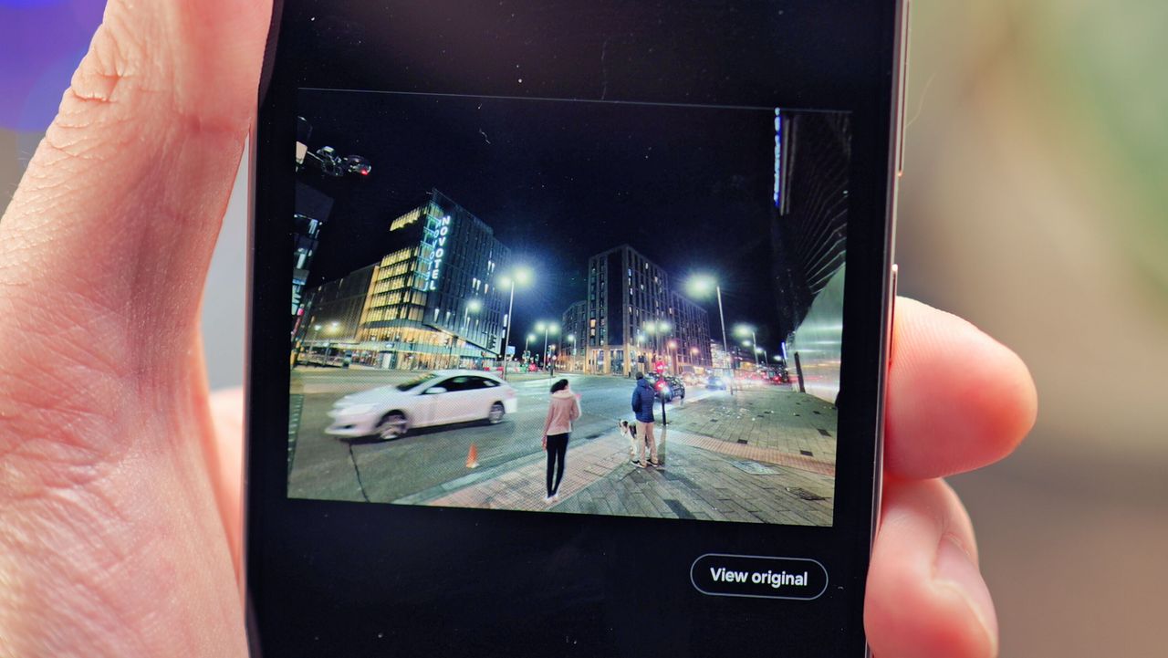 Samsung Galaxy S24 phone held in a hand with the screen showing photo editing software