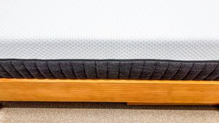 One side of the Emma Luxe mattress on a bed frame