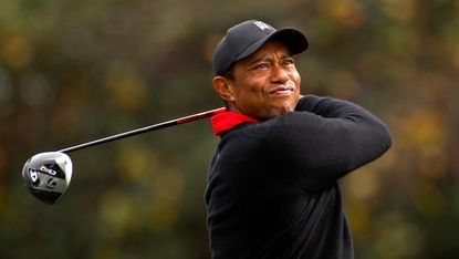 Tiger Woods holds his pose after driving at the PNC Championship in 2023