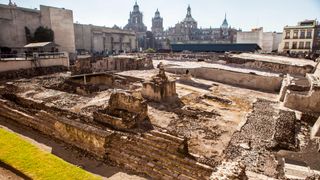 An image of the ruins of the Templo Mayor which was once one of the main temples of the Aztecs. Only the foundation is left and some steps at the building’s side.