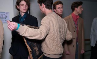 Group of male models arranging their clothing