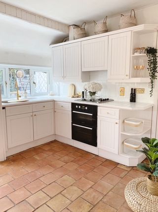 Becky Lane's new white kitchen with tiled floor and gold and wooden accents and accessories