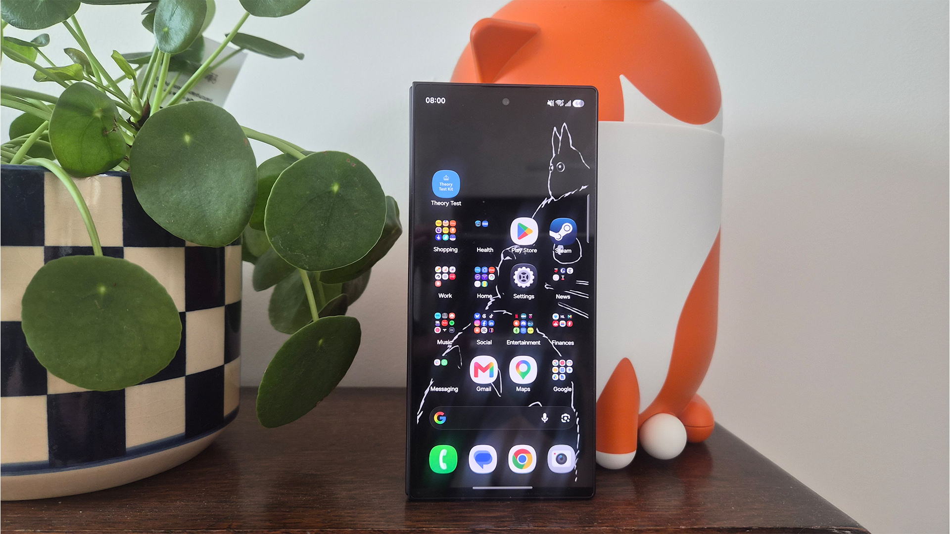 Samsung Z Fold 8 Ultra smartphone upright on wooden furniture next to plant pot