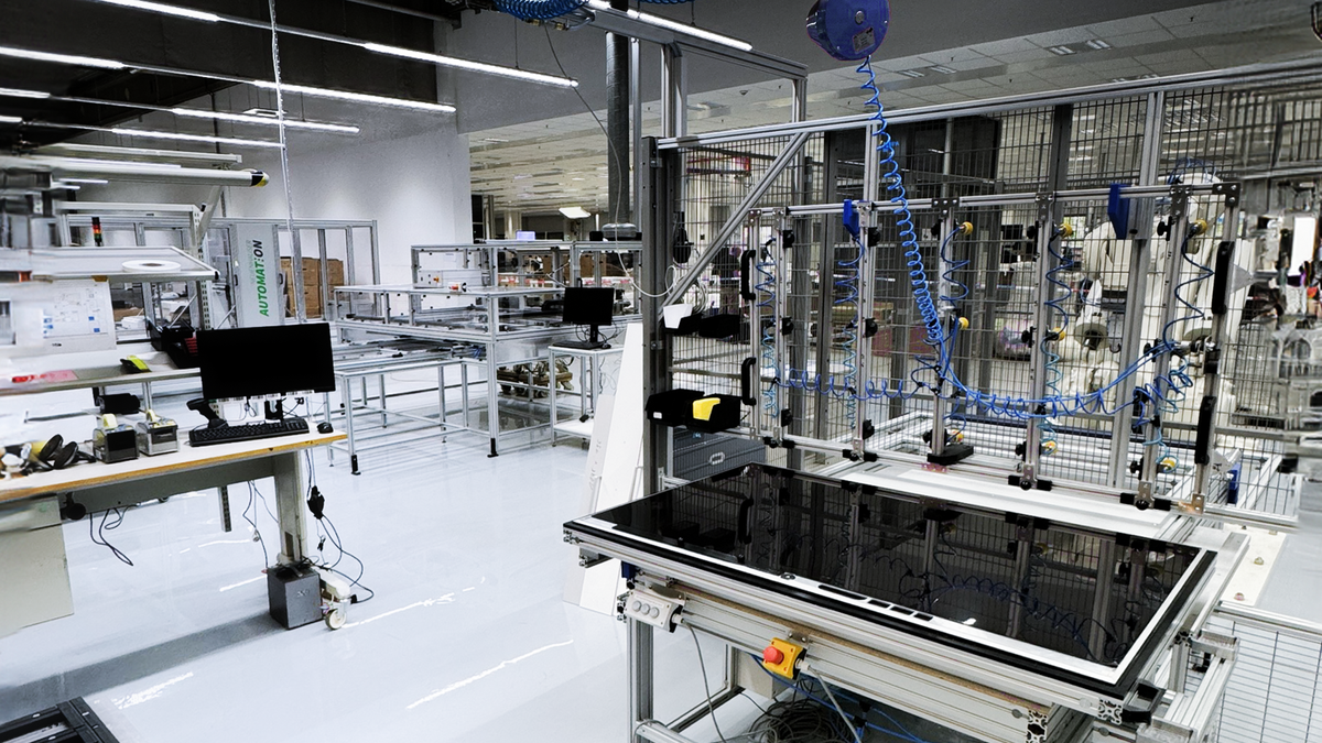 Loewe OLED production plant with various mechanical tools and a large panel in the foreground