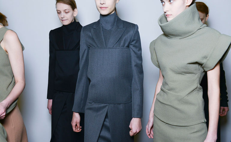 One woman in a black outfit, one in blue and one in grey
