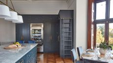 A blue kitchen with a transparent fridge