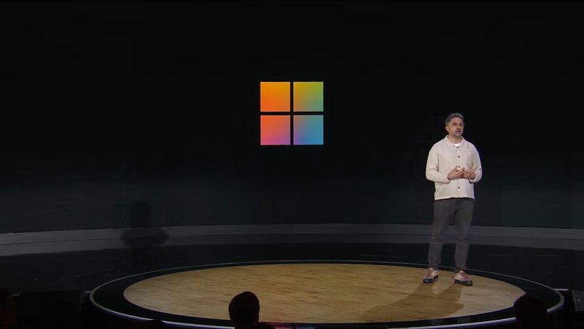 Mustafa at Microsoft 50th Anniversary event in front of Windows logo