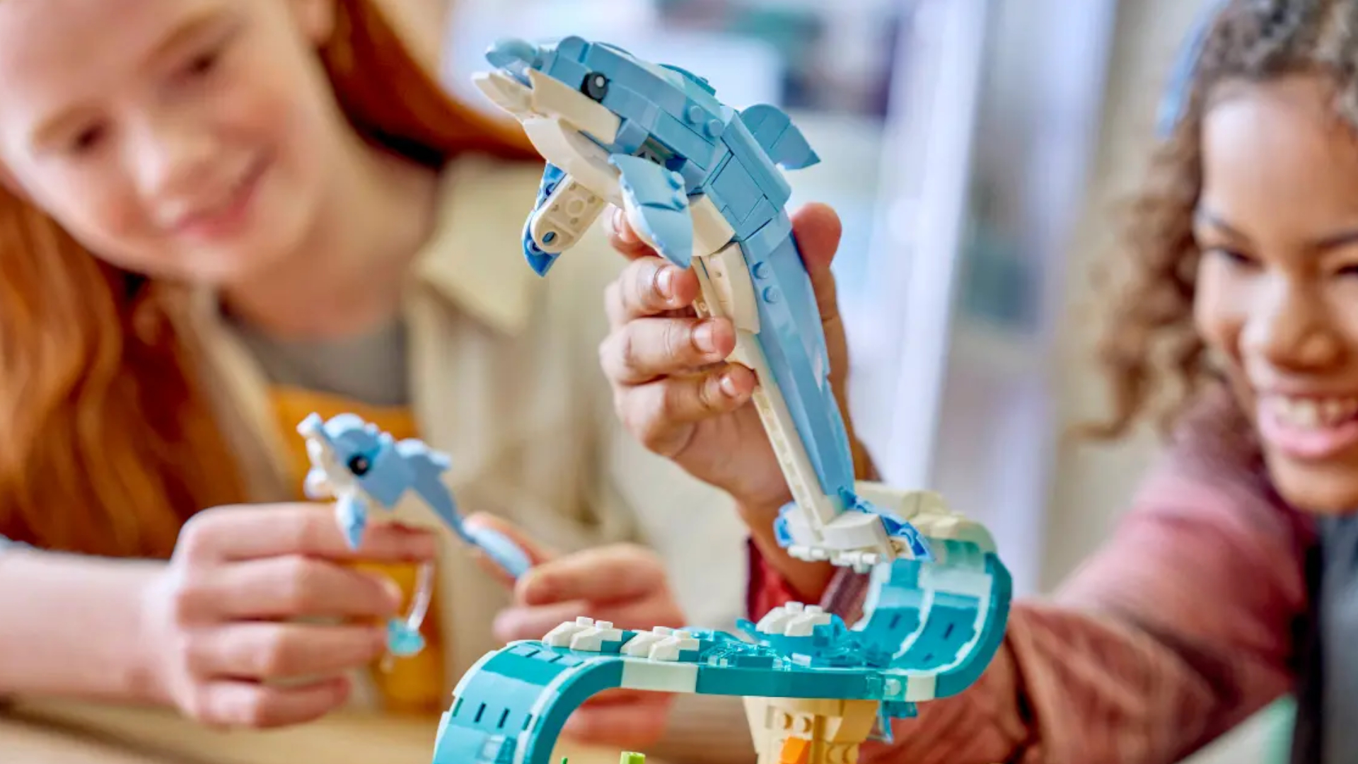 Children smile as they play with Lego dolphins