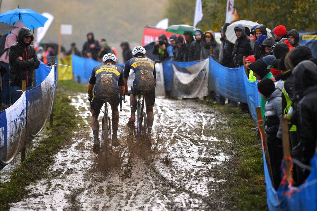 OUDENAARDE BELGIUM NOVEMBER 01 Riders competing in a muddy section of the circuit during the 32nd Koppenbergcross Grand Prix Jolien Verschueren 2021 Mens Elite Koppenbergcross Oudenaarde X2OBadkamersTrofee on November 01 2021 in Oudenaarde Belgium Photo by Luc ClaessenGetty Images