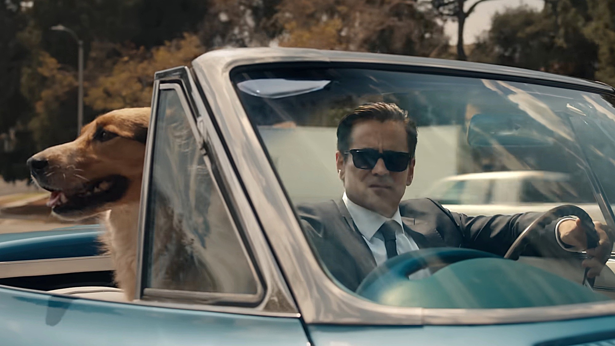 Colin Farrell as John Sugar is shown driving a classic convertible with a dog sitting beside him