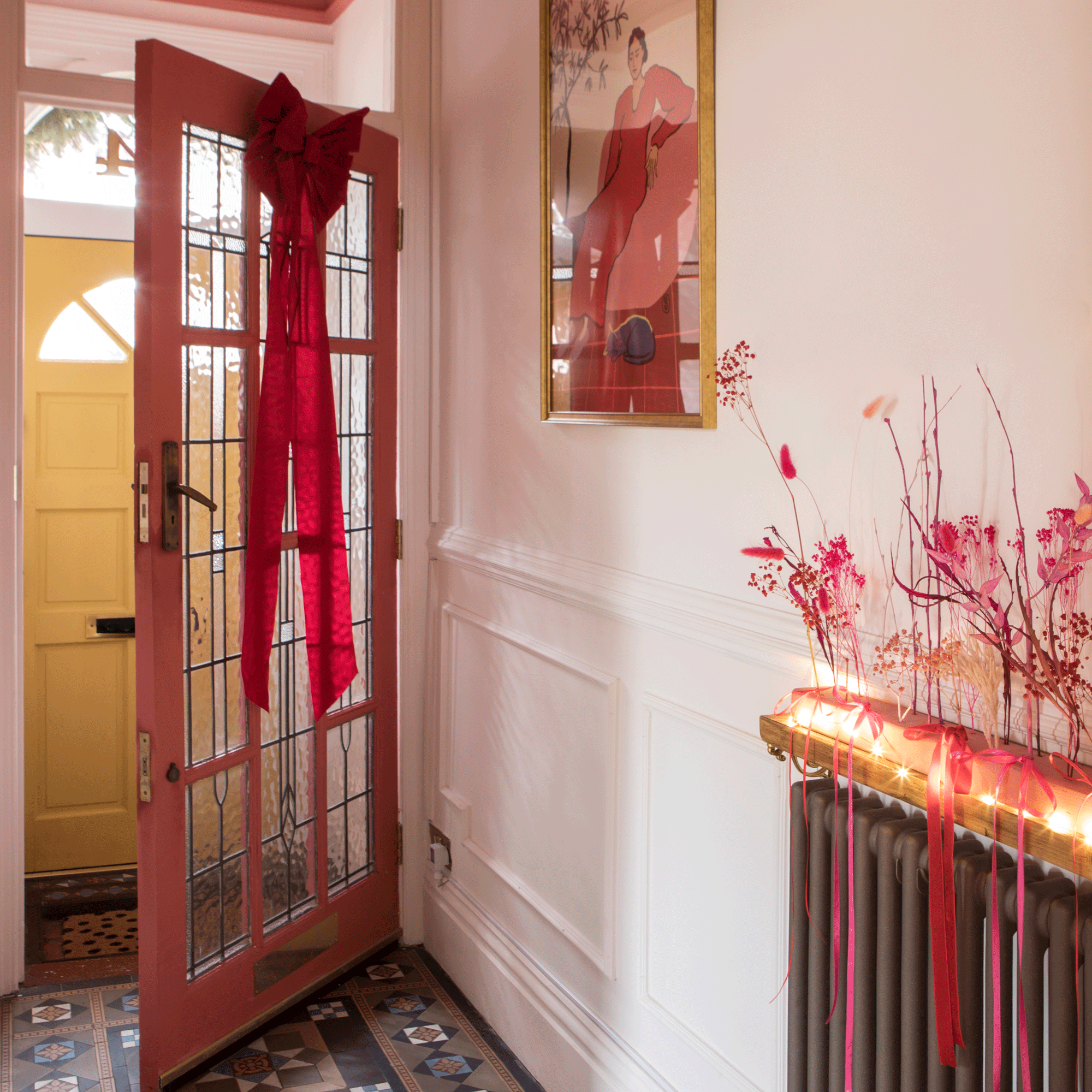 colourful hallway with a pink internal door and a yellow front door and patterned traditional floor tiles