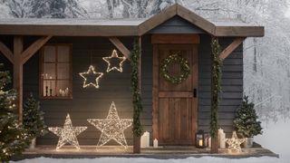Log cabin in snowy woodland with light themes outdoorChristmas decorating idea