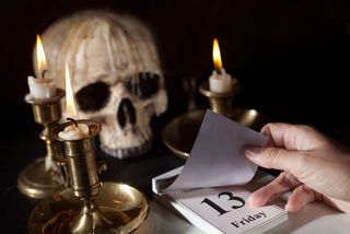 A skull and candles next to a calendar showing Friday the 13th.