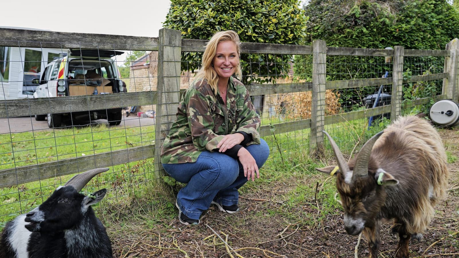 Josie Gibson on her farm next to two of her goats