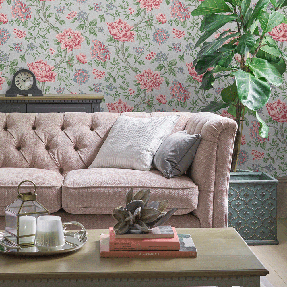 Living room with a pink sofa against flowery wallpaper