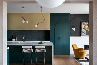 Kitchen with forest green painted cupboard, forest green splashback and gold upper cabinets