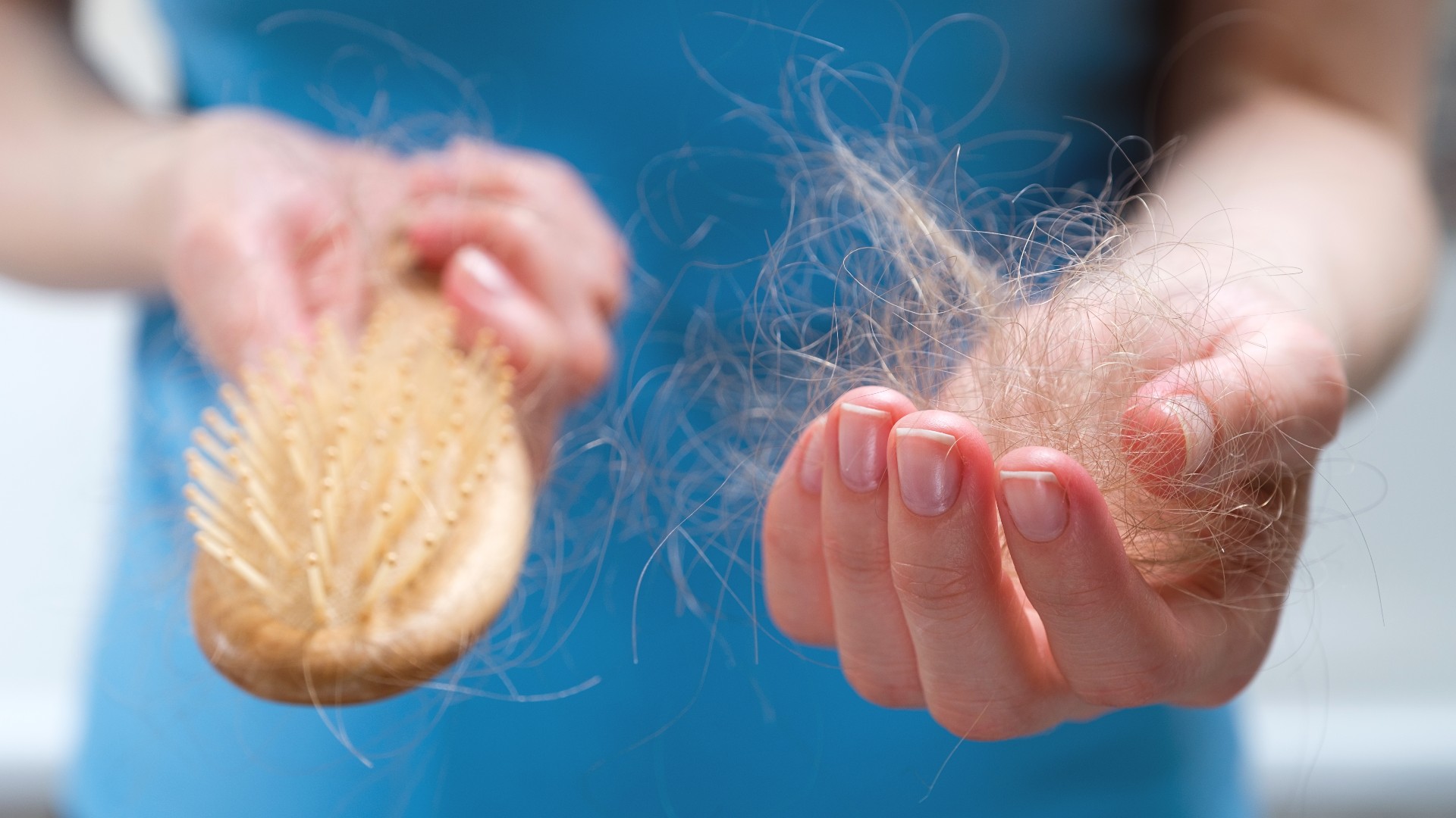 Woman cleaning hair from wooden brush