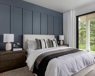 modern bedroom with dark blue feature wall and white bedding