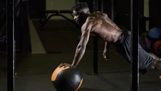 person working out on a medicine ball in a gym