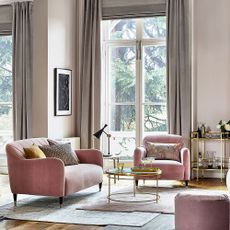 living room with pink sofa and wooden flooring