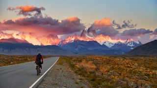 A bikepacker with stunning mountains in the background