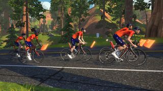 Zwift Ineos Grenadiers are shown virtually here riding as a team on Zwift. There are five riders on the road shown side on with trees and hills in the background