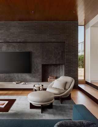 A living room with a white beige sofa chair and pouf