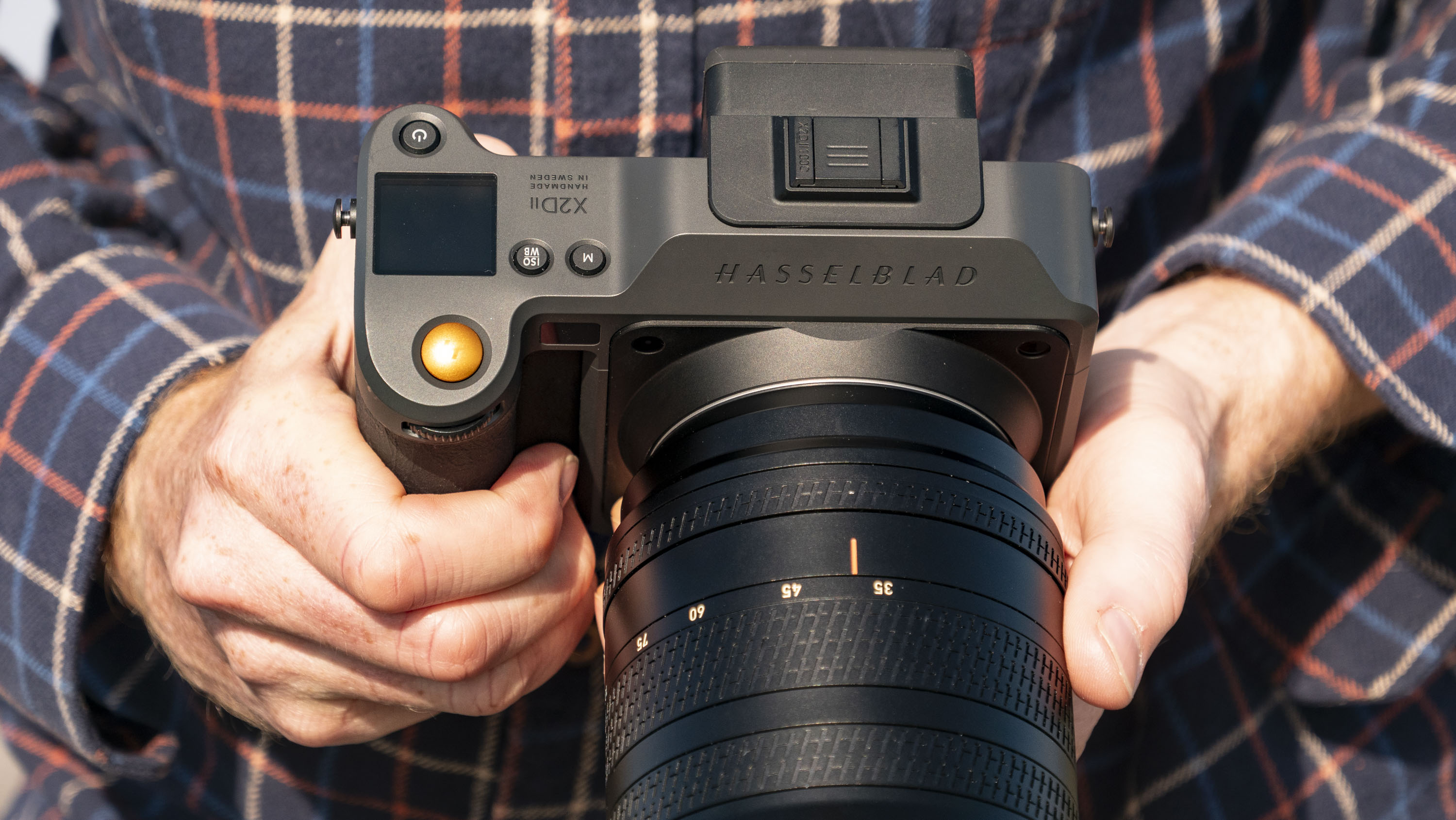 Hasselblad X2D II 100C camera in the hand, outdoors at first light