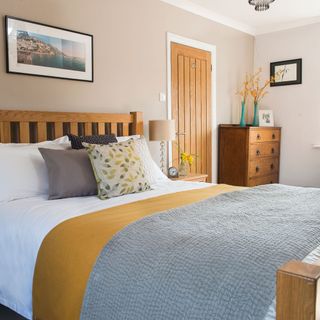 bedroom with peach colour wall wooden bed with designed cushion