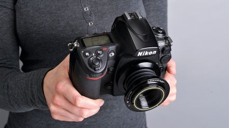 Person holding Nikon D700 with Lensbaby lens attached 