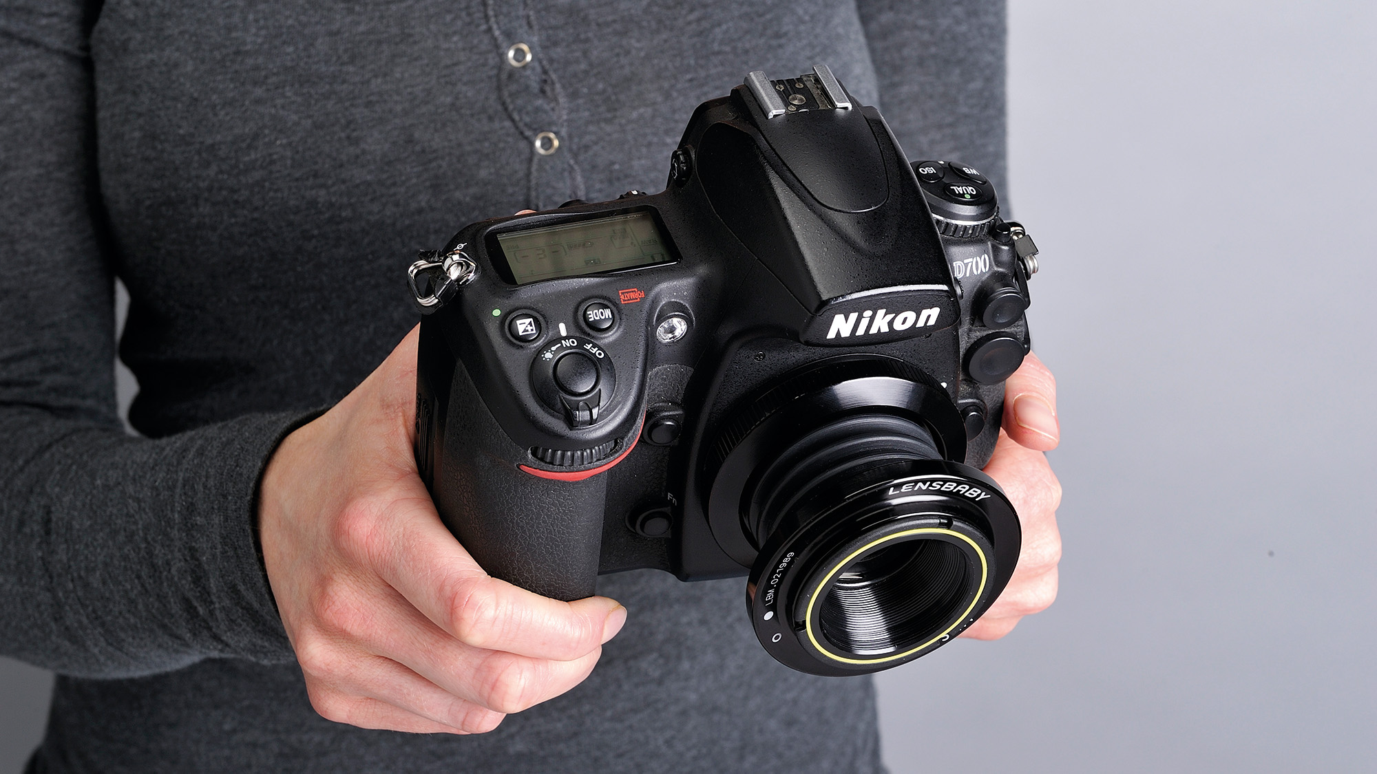 Person holding Nikon D700 with Lensbaby lens attached