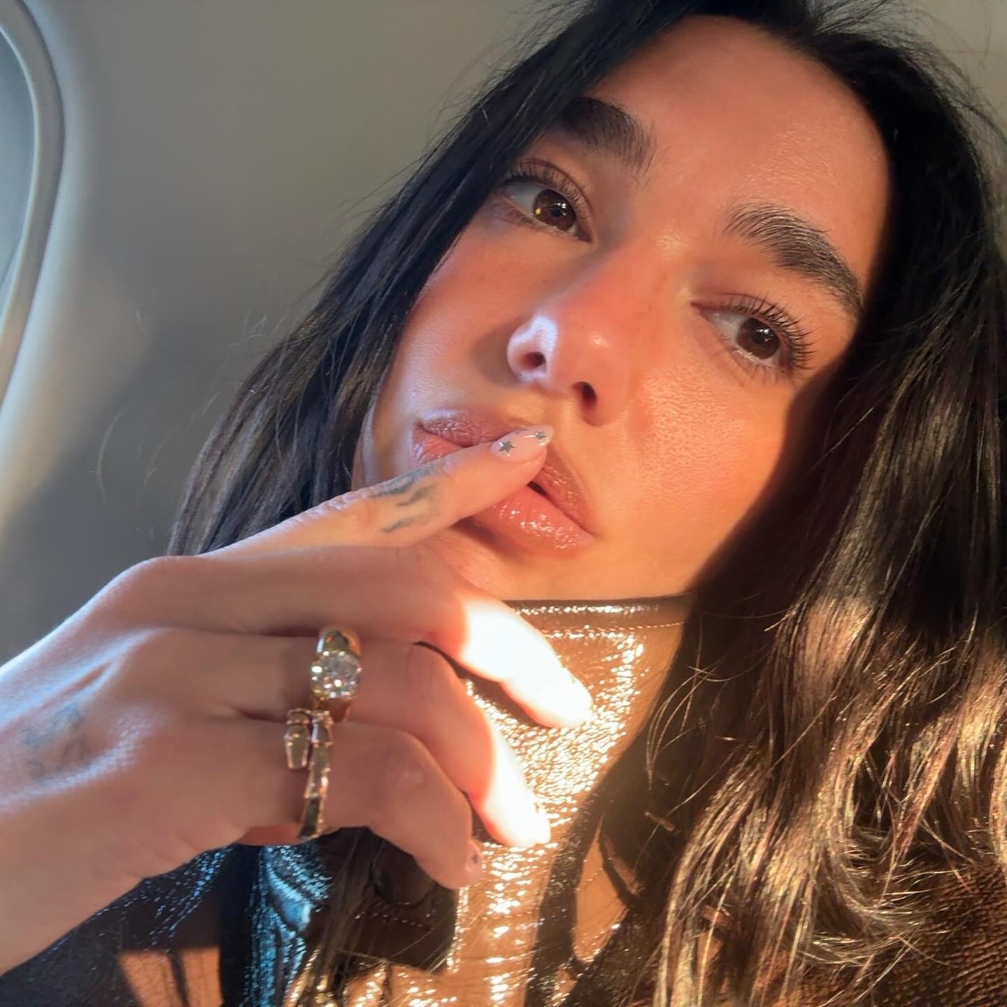 A selfie of Dua Lipa wearing a milky star manicure
