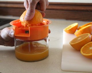 Camryn Rabideau using Mainstay juicer to squeeze oranges