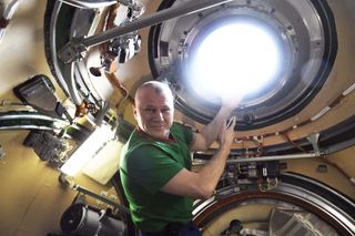 Russian cosmonaut Oleg Novitskiy shows off his window on Earth inside the new Nauka science module on the International Space Station.