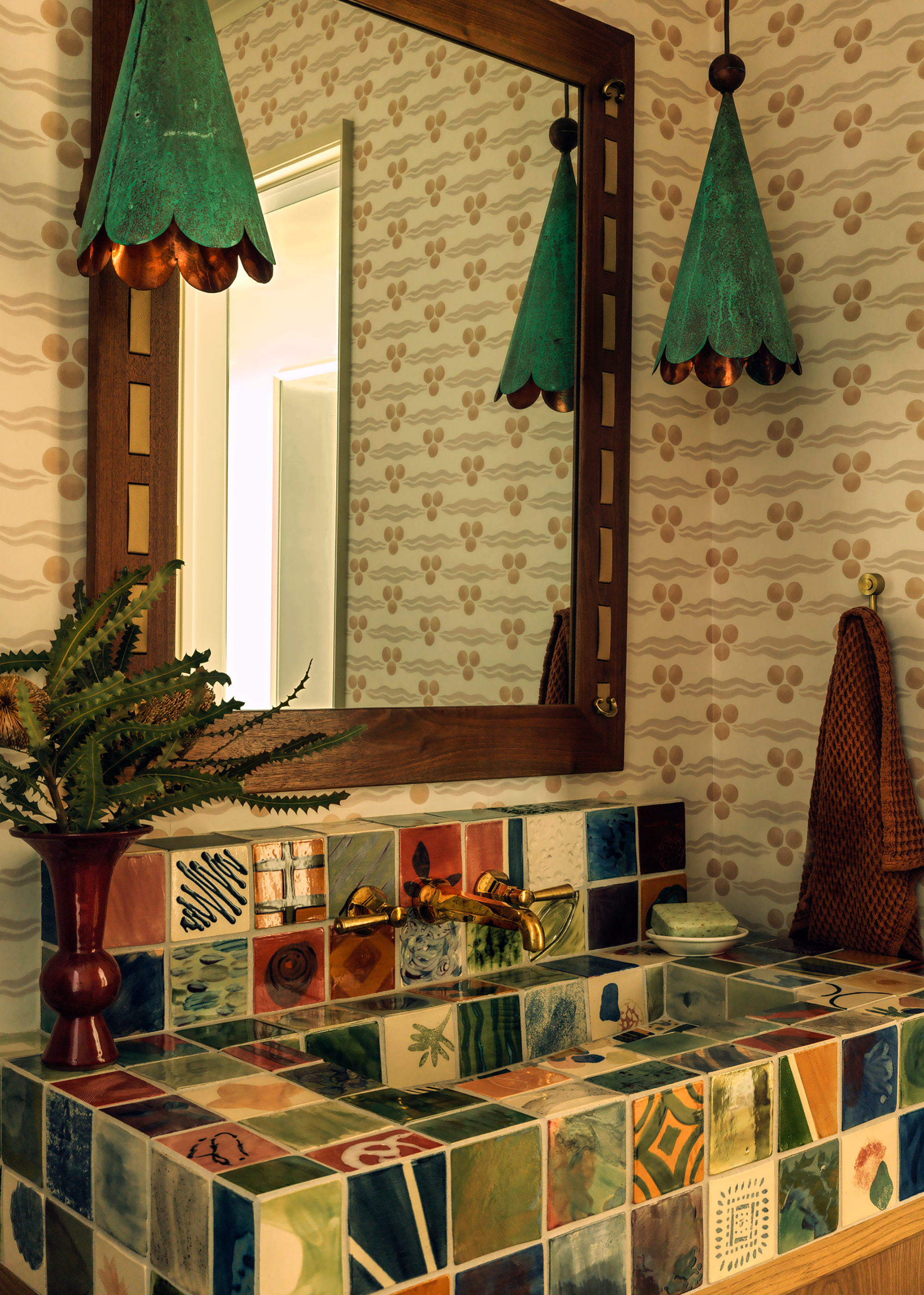 a full painted tiled sink in a wallpapered bathroom