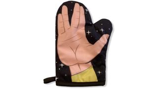 A black oven mitt with a human hand on the front with two fingers either side of the middle pulled apart to make a 'V' shape.