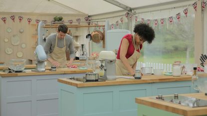 bake off tent with two contestants baking