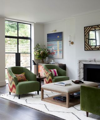 Green armchairs, white rug, black framed window door