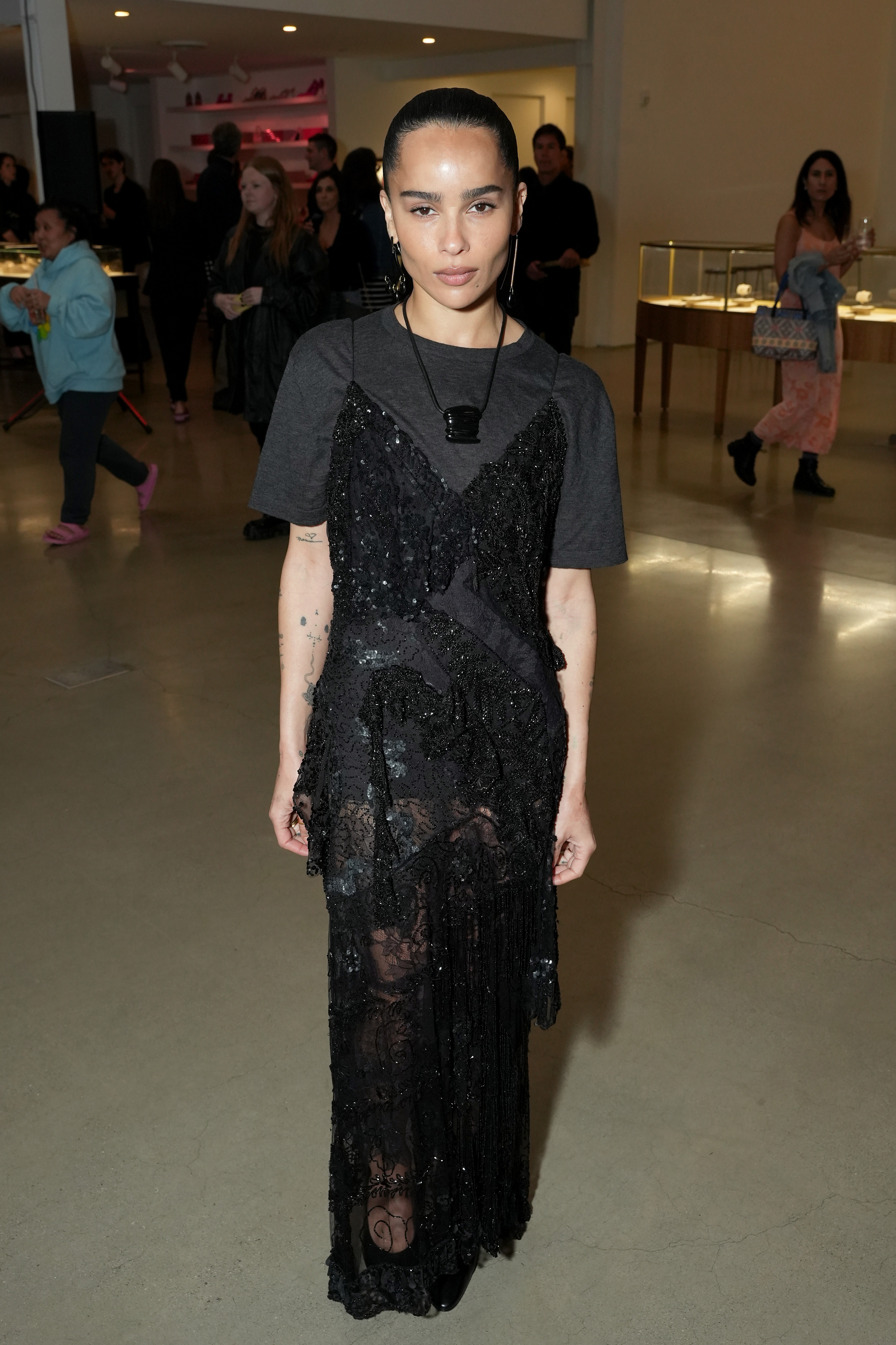 An image of Zo&amp;euml; Kravitz wearing a boxy t-shirt, embroidered maxi dress and pendant necklace as part of her autumn capsule wardrobe.